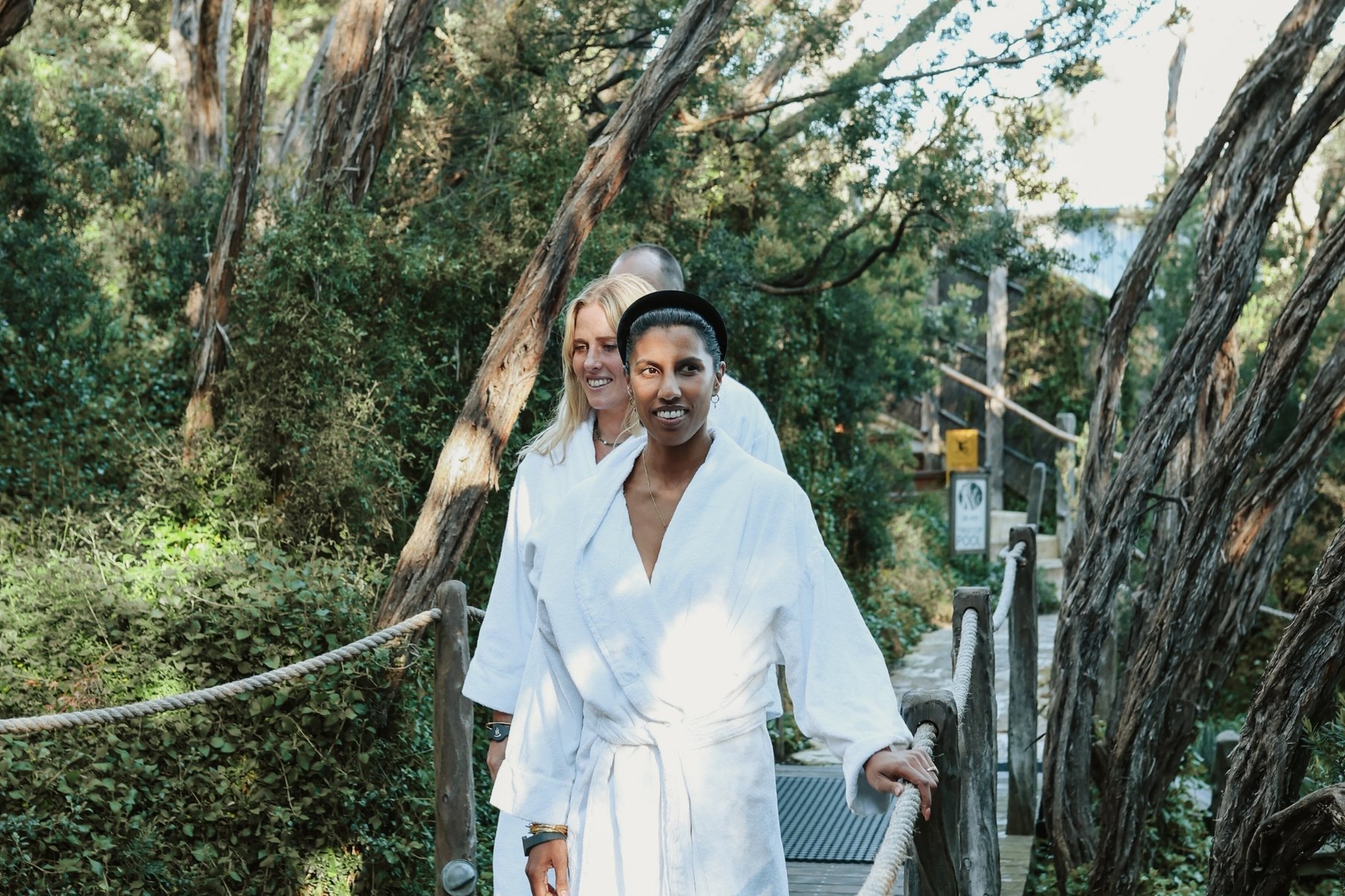 A group of people walking through Spa Dreaming Centre in white robes