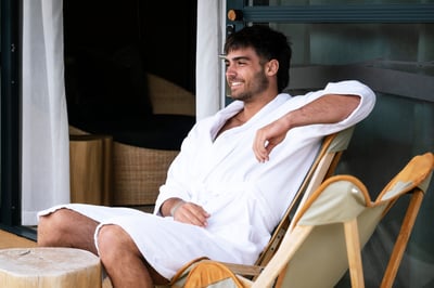 A person sitting on a lounge chair on the Glamping tent deck