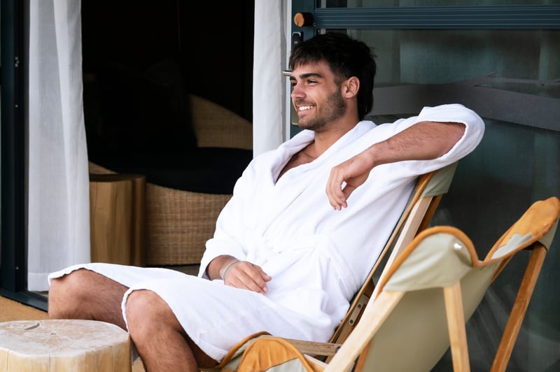 A person sitting on a lounge chair on the Glamping tent deck