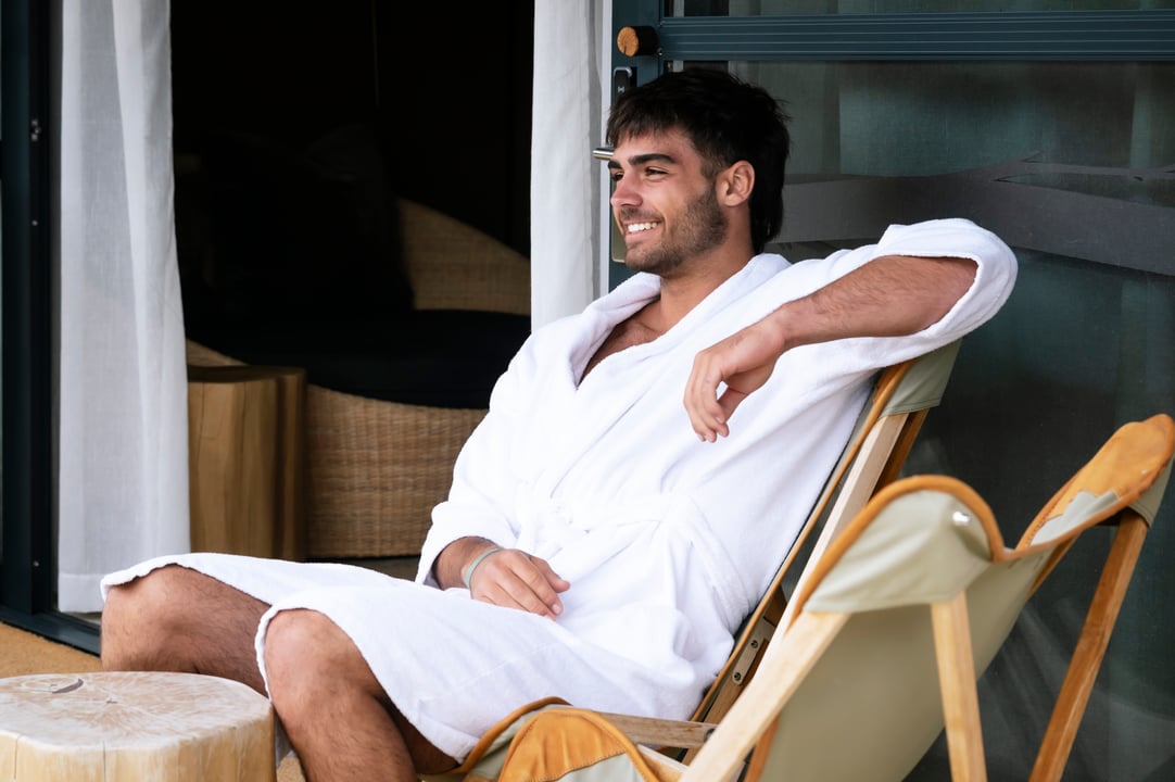 A person sitting on a lounge chair on the Glamping tent deck