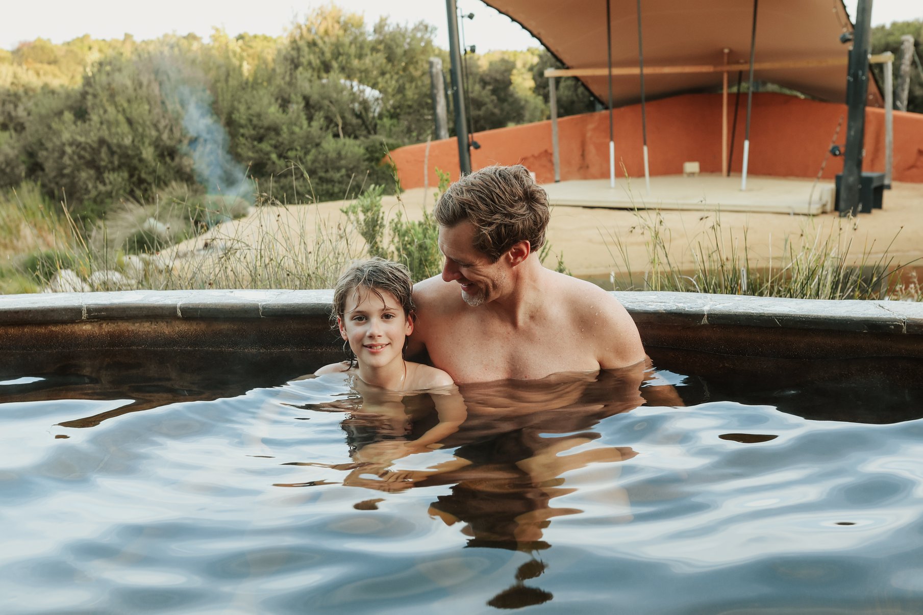 A father and son bathing in the Amphitheatre hot springs
