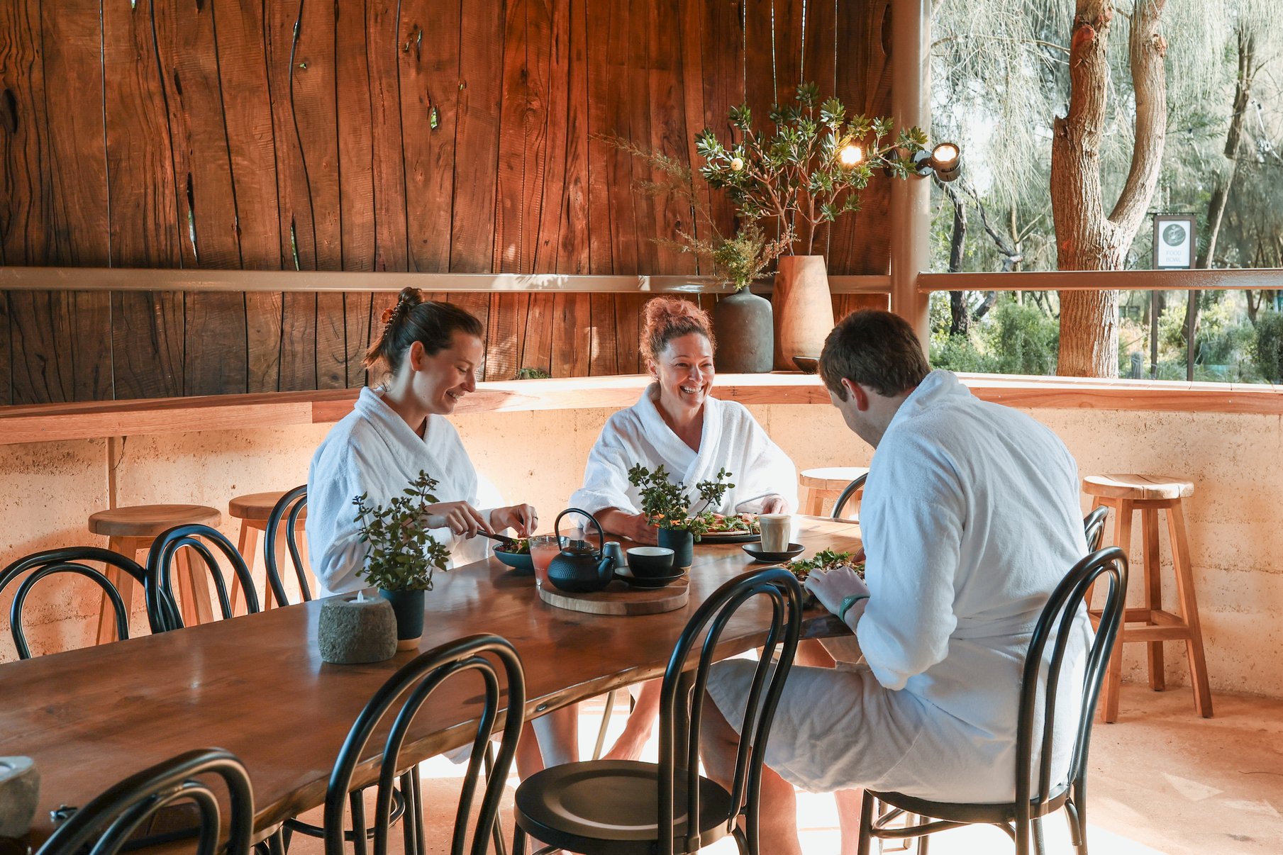 Three people in white robes dining in the Amphitheatre Cafe
