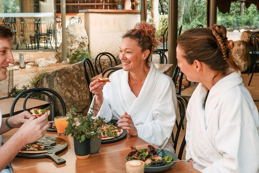 A group in white robes enjoying pizzas in the Amphitheatre Cafe