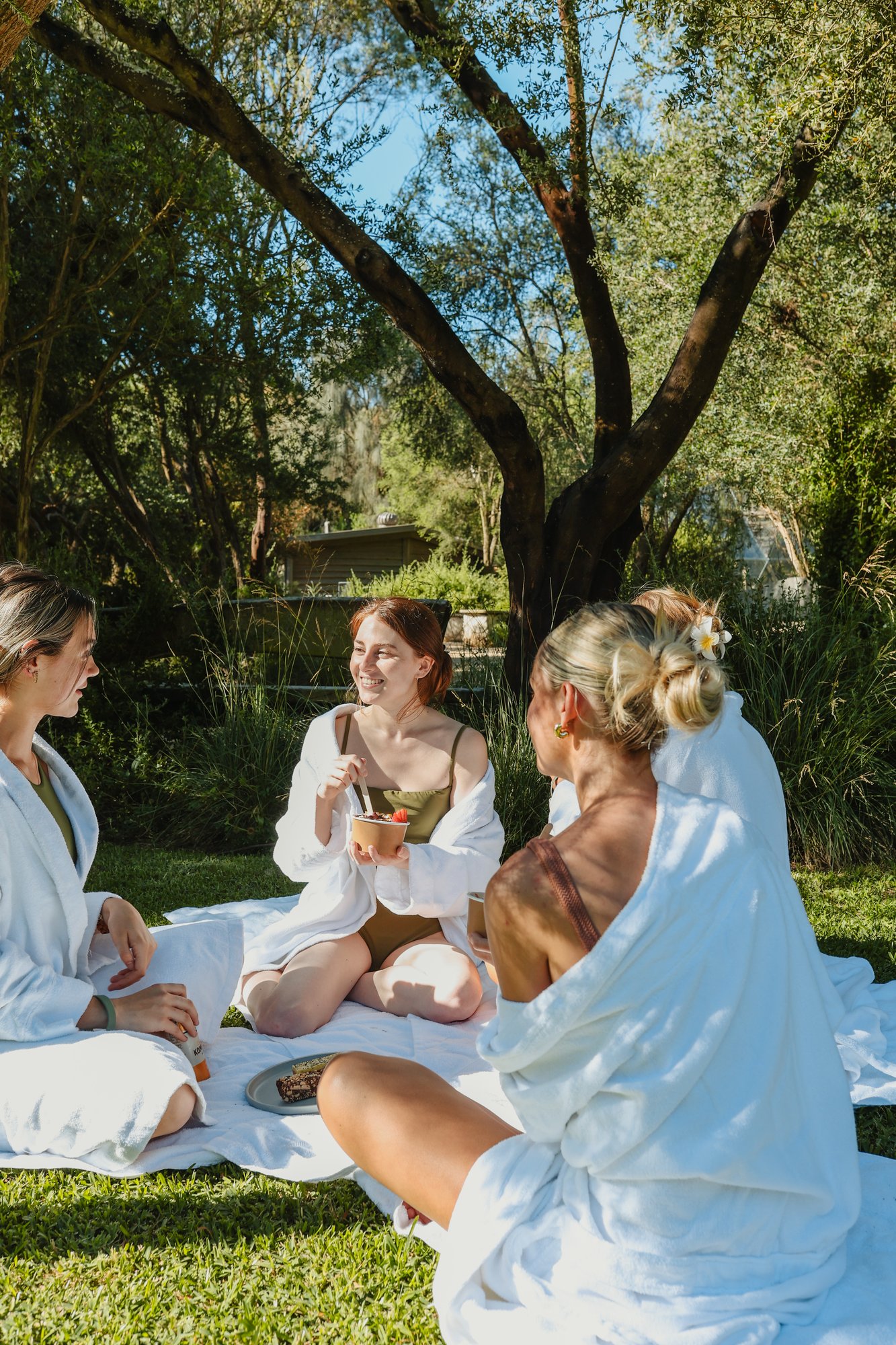 A group of friends sitting on the lawn in white robes
