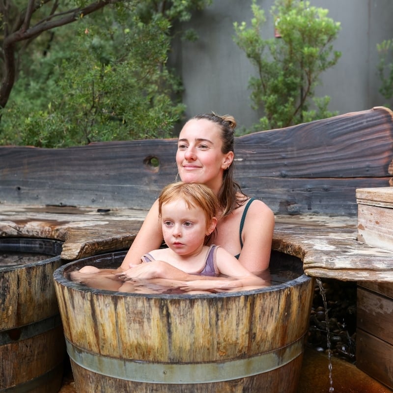 A mother and daughter in a bathing bucket