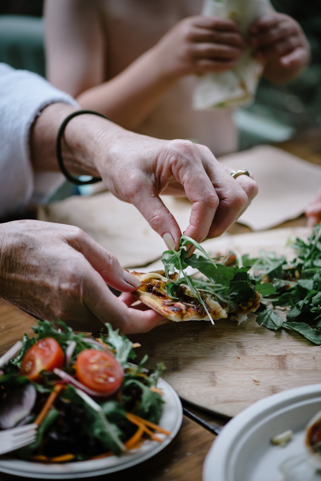 A person eating a pizza in a white robe