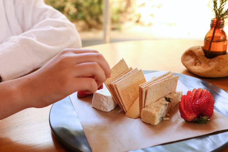 A person eating a cheese plate in the Bath House Cafe