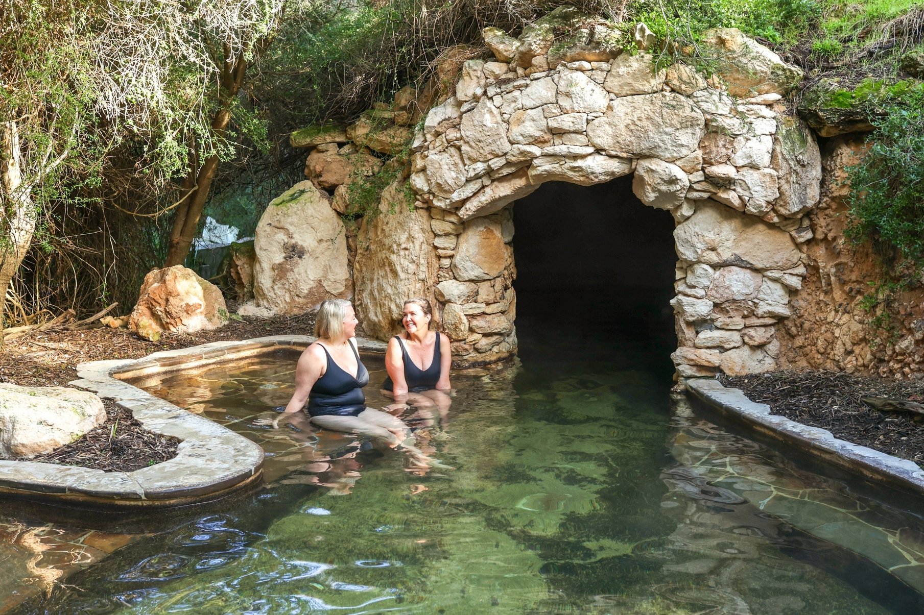 Two friends bathing in the Cave Pool in the Bath House