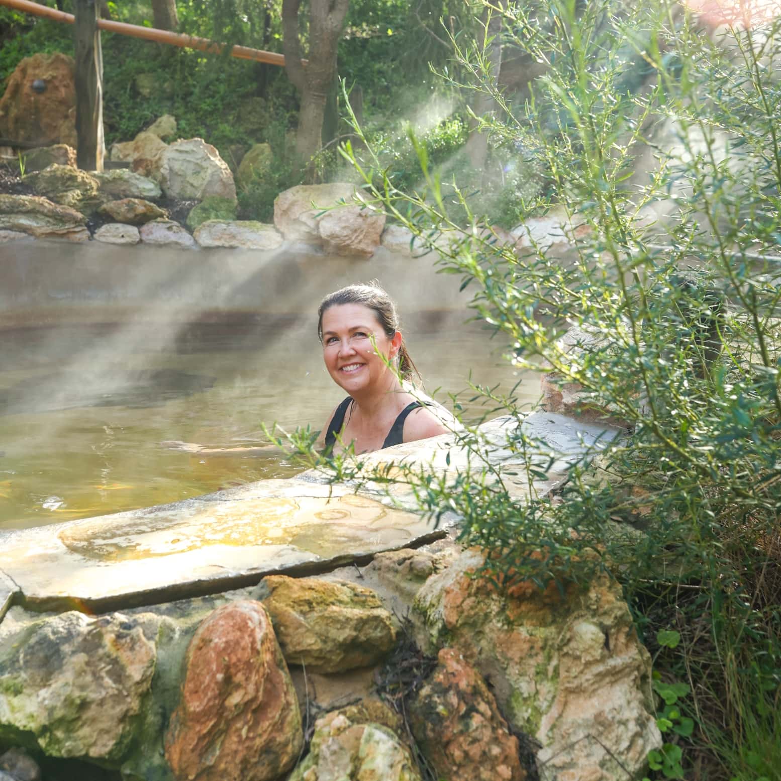A woman bathing in hot spring surrounded by nature