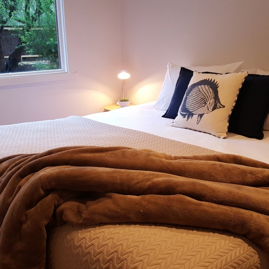 A bed with a copper throw rug
