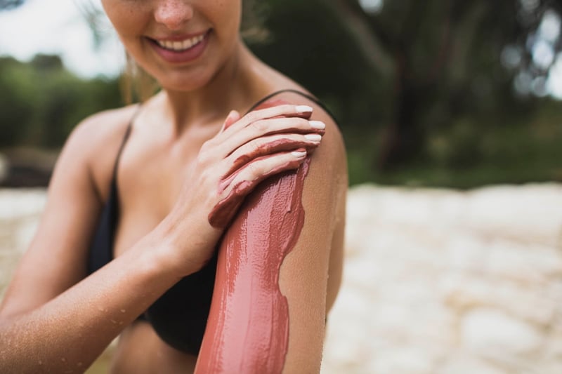 A person rubbing clay on their arm