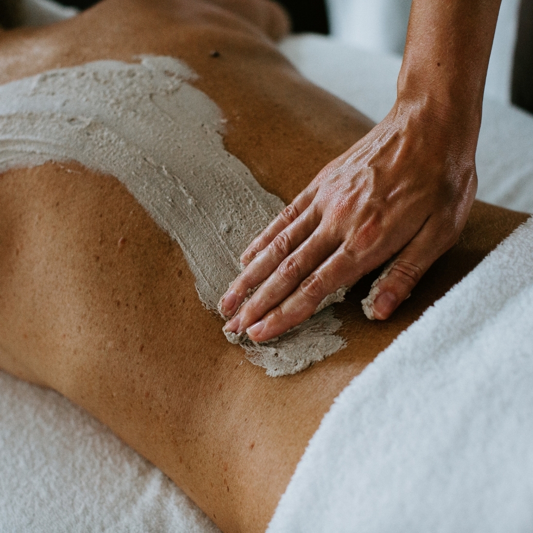 A person receiving a body scrub