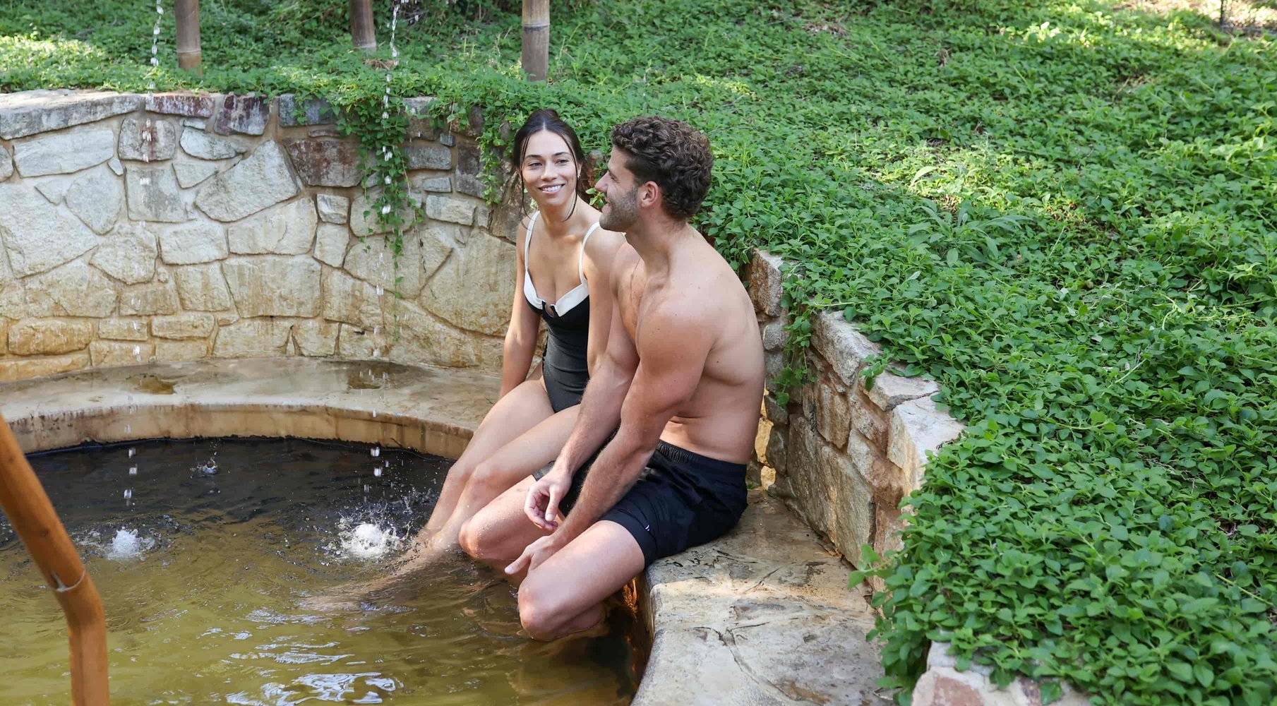 Christmas gifts header image: A couple with their feet dangling in a hot spring.