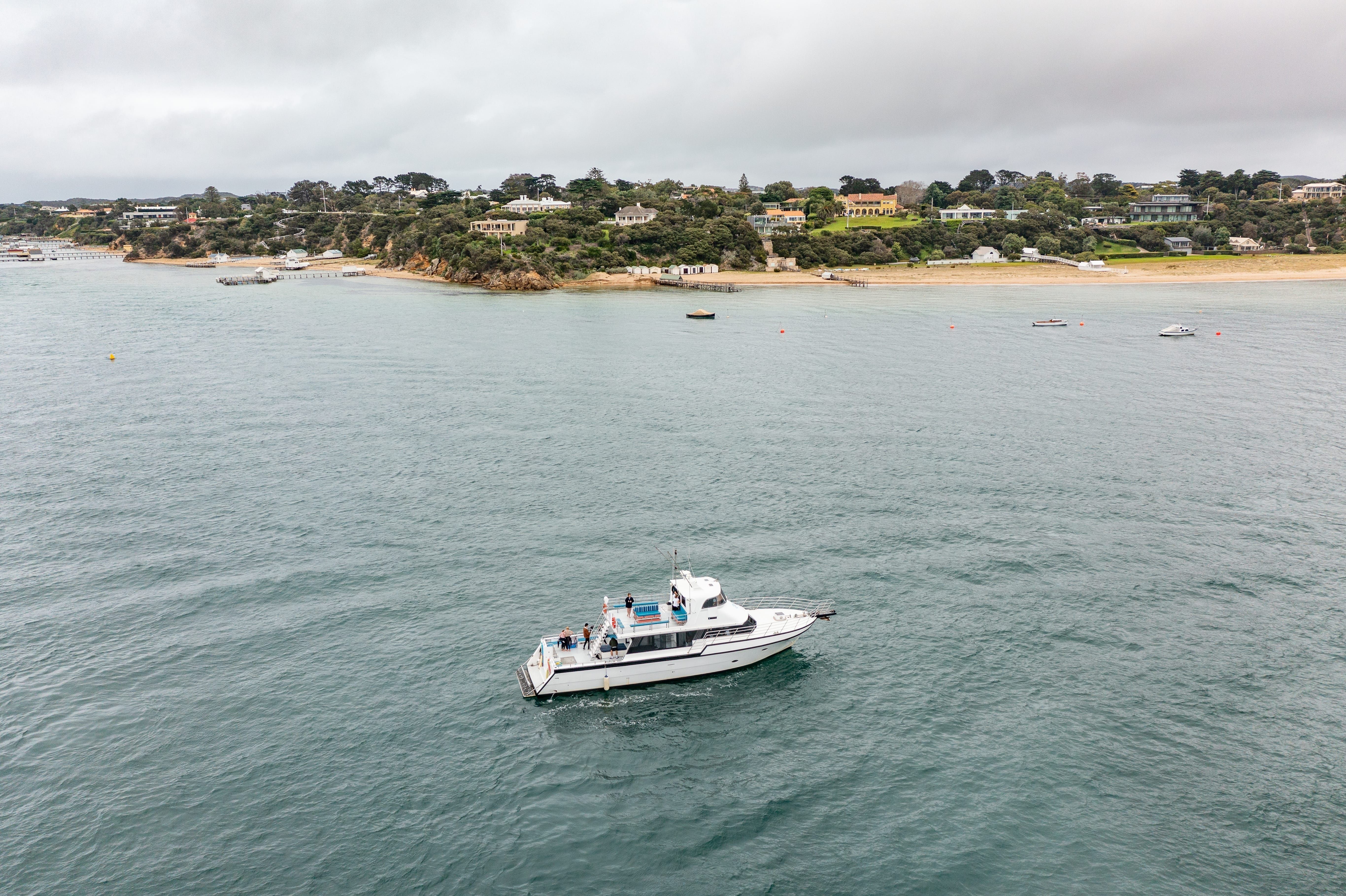 A boat in the water with a sandy shoreline