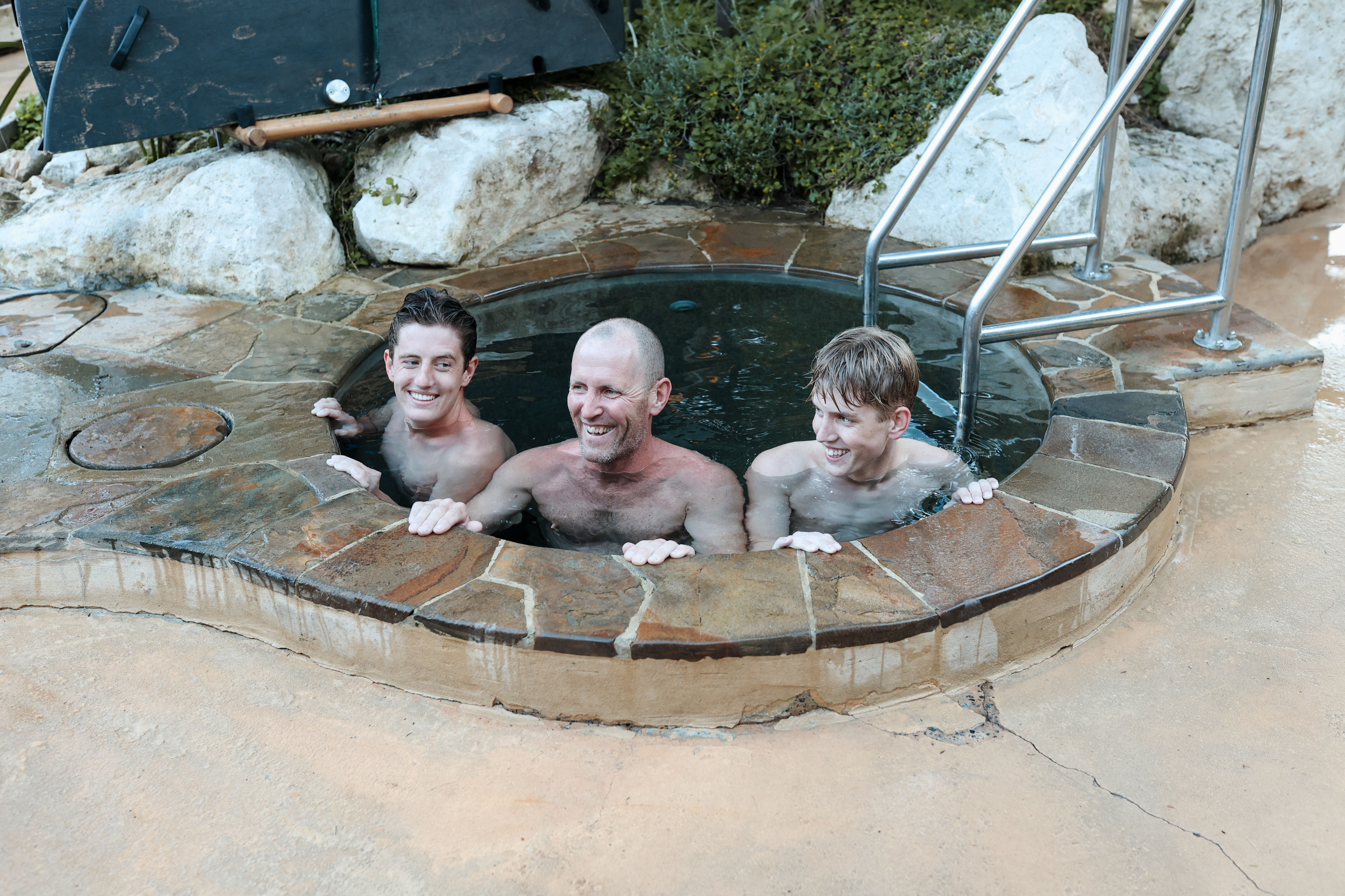 A father and two sons bathing in the cold plunge pool