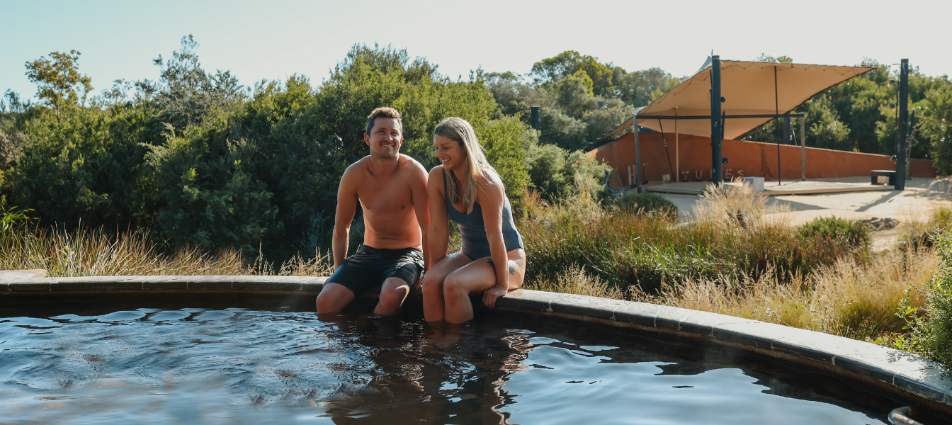 A couple sitting on the ledge of an Amphitheatre pool