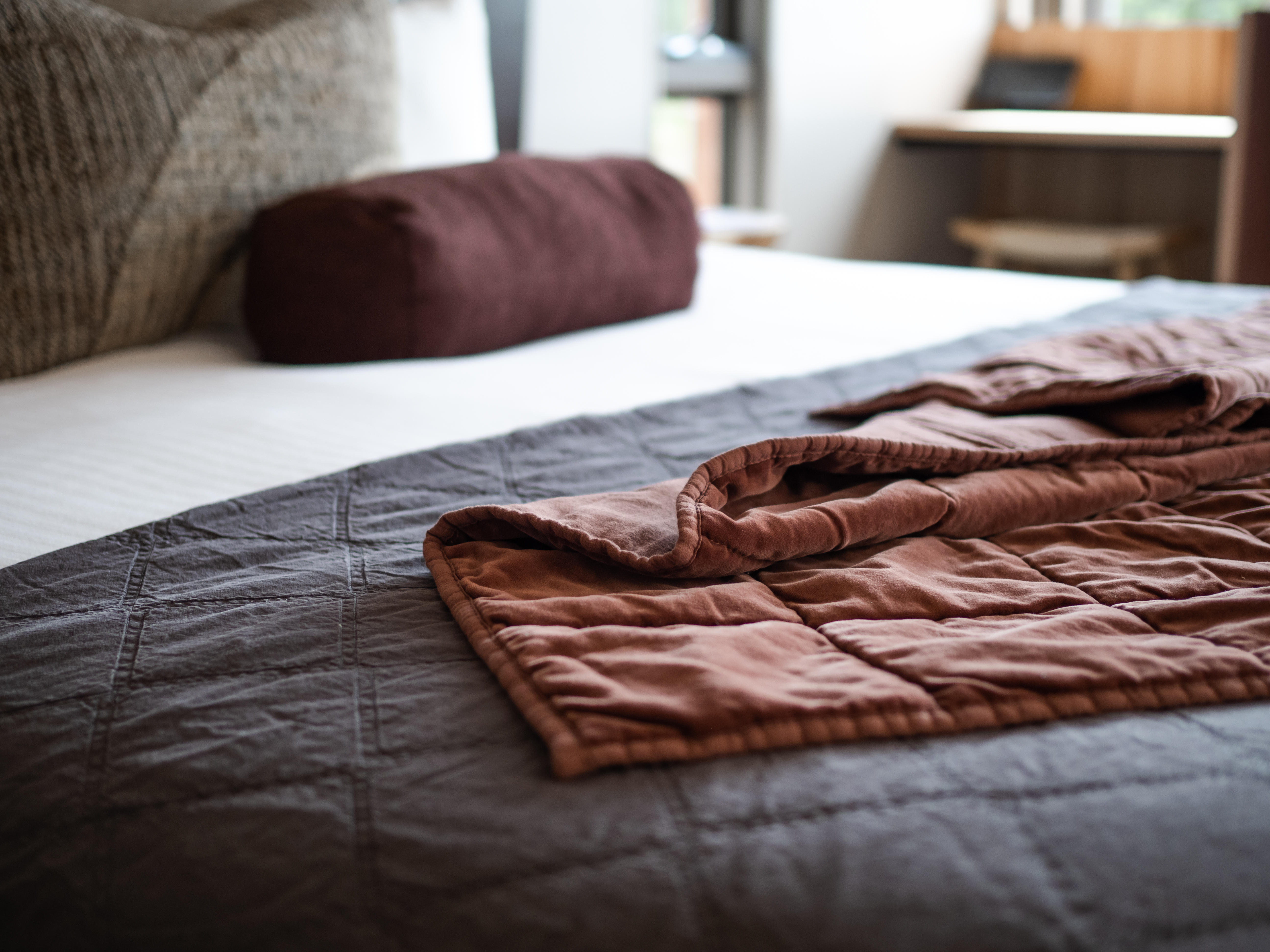 A bed with a throw blanket