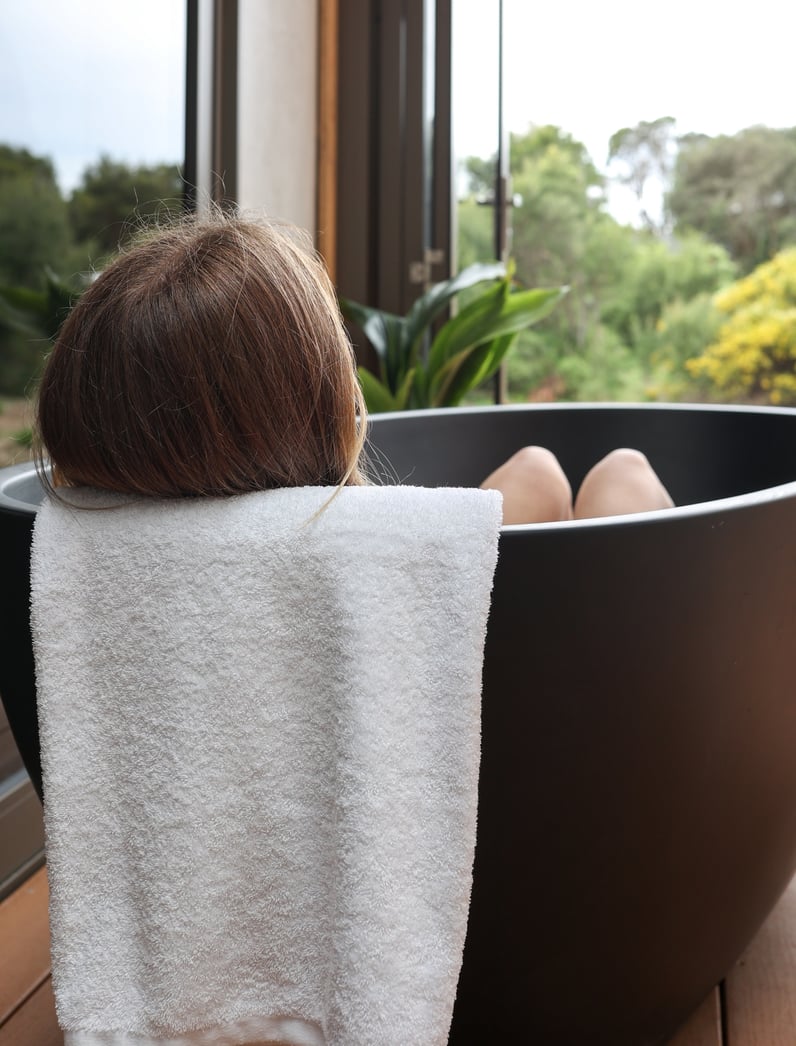 A woman in a private bath in the Eco Lodges