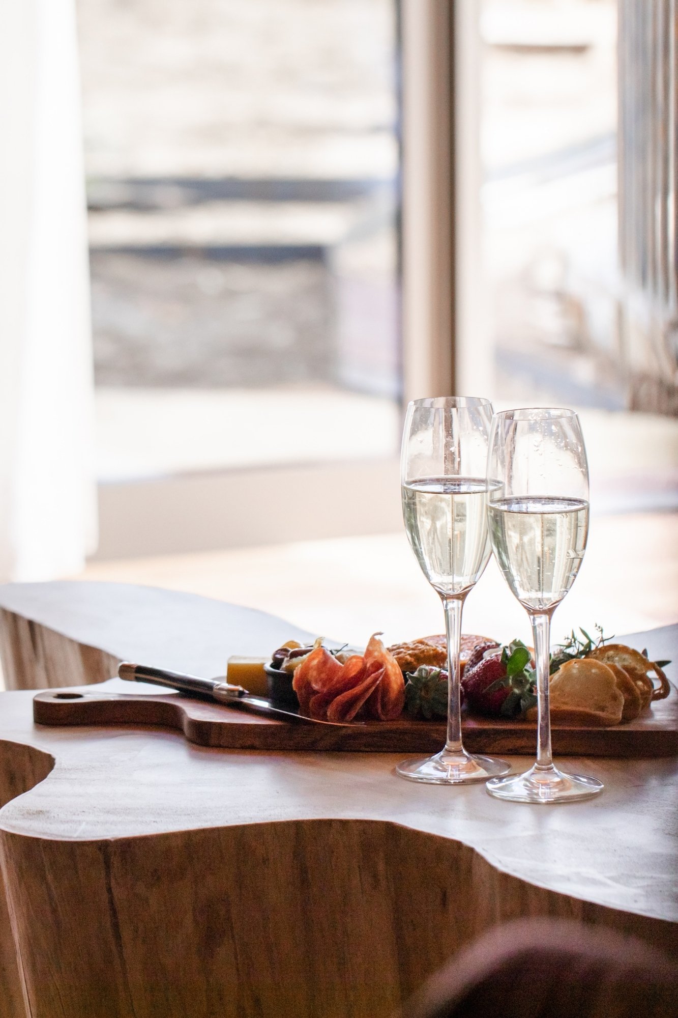 A cheese platter and two glasses of bubbles