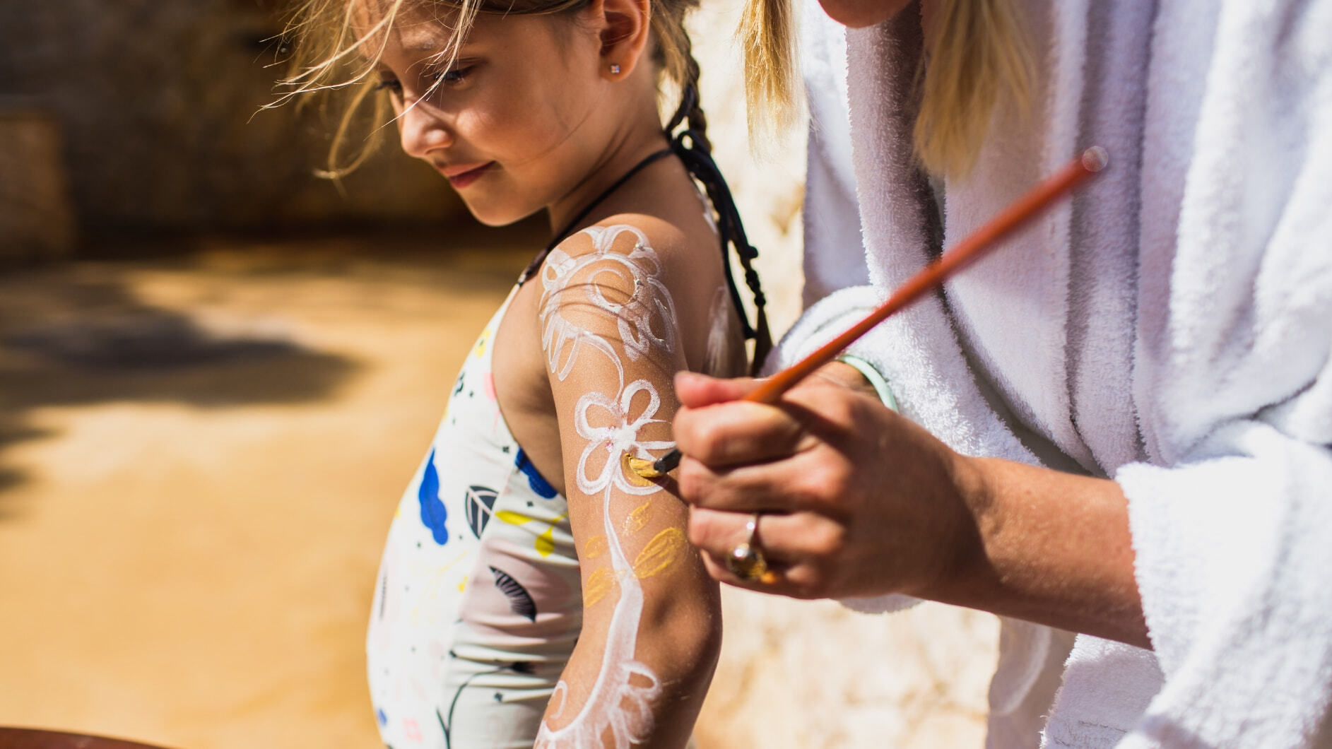 A young girl doing the Family Body Clay Ritual