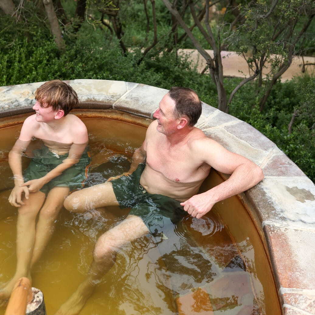 A father and son bathing in a hot spring in the Bath House