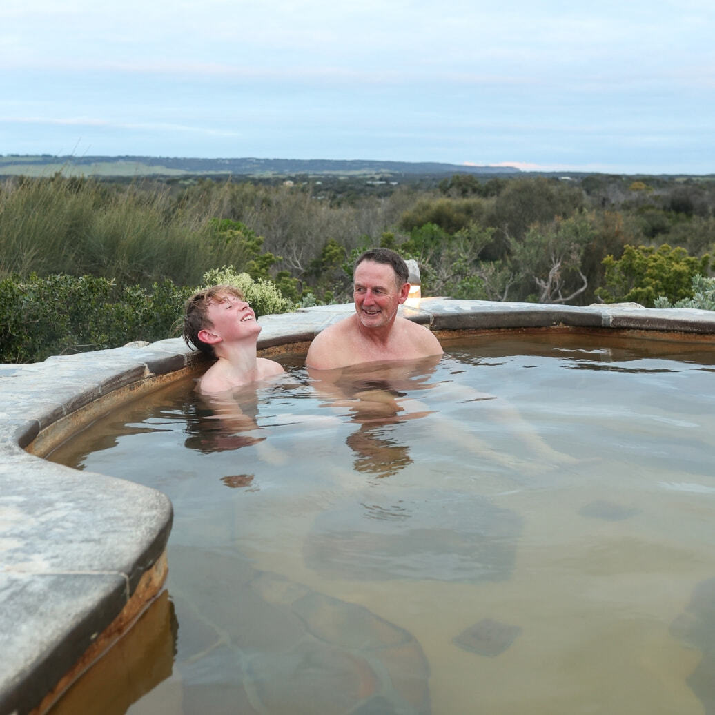 A father and son bathing in hot springs at Hilltop