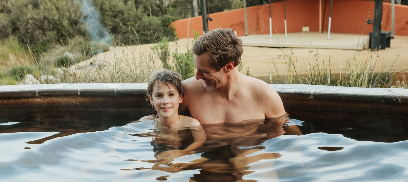 A father and son bathing in the Amphitheatre hot springs