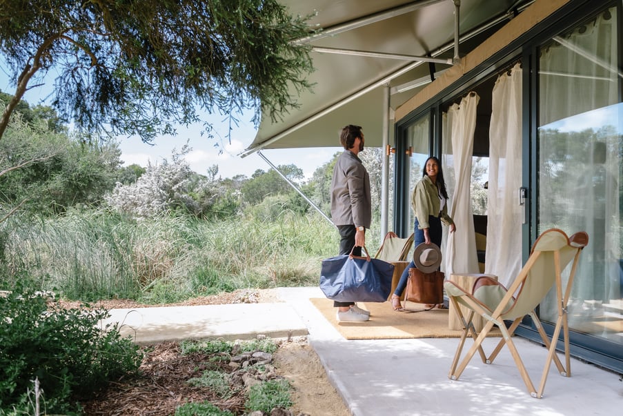 A couple walking into a Glamping tent