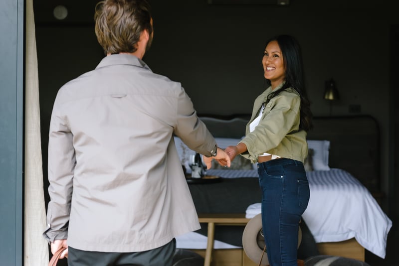 A couple walking hand in hand into a Glamping tent