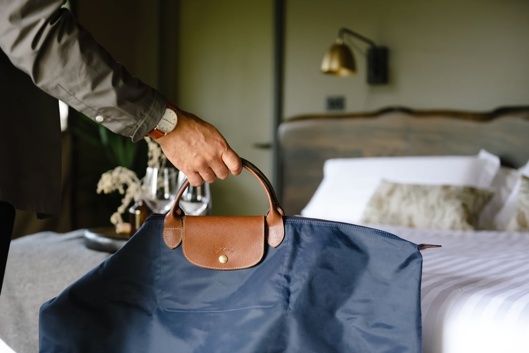A man putting his bag down in a Glamping tent