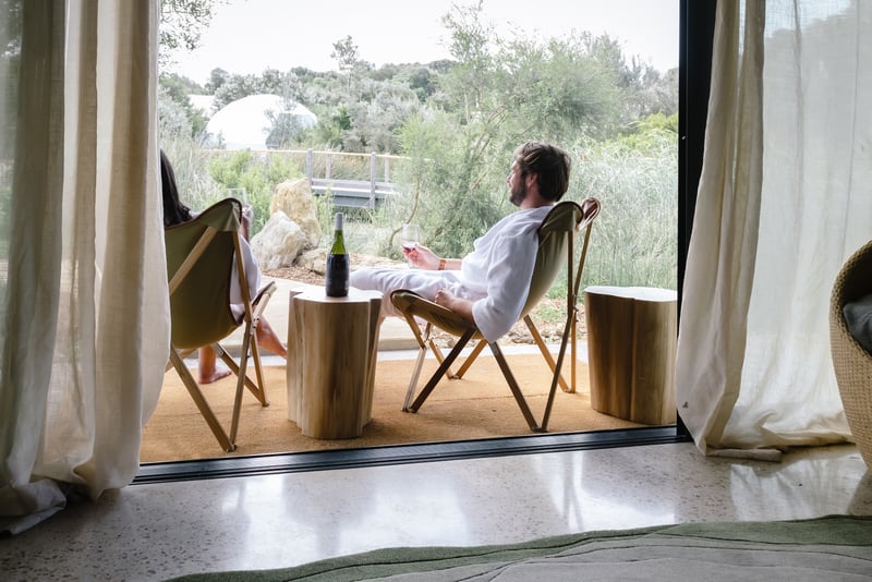 Two people on deck chairs in their Glamping tent