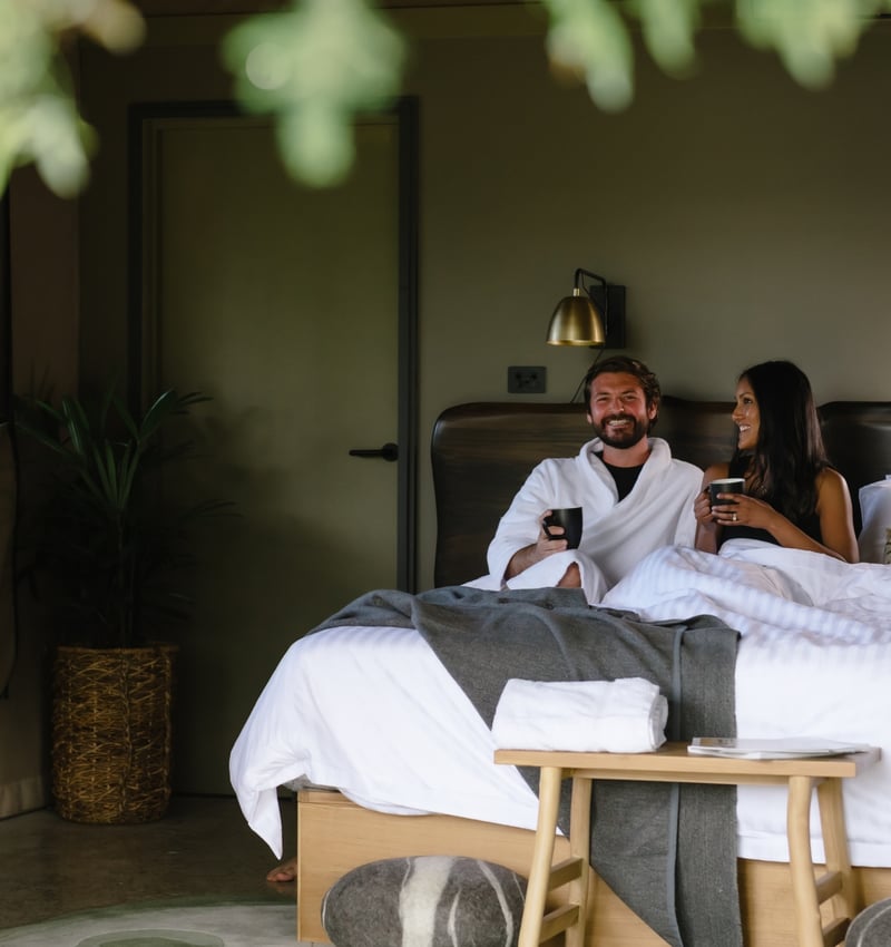 A couple lying in a Glamping bed