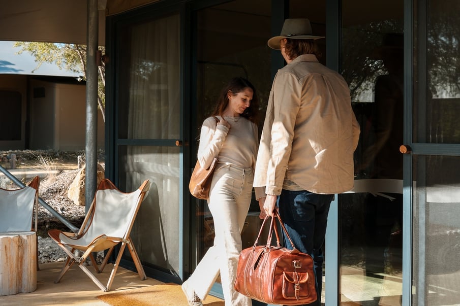A couple walking into a Glamping tent
