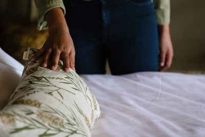 A woman's hand touching a decorative cushion