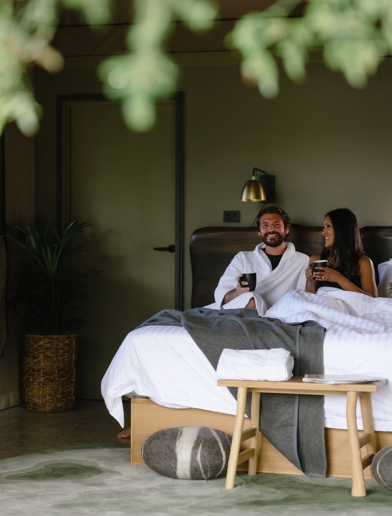 A couple lying in a Glamping bed