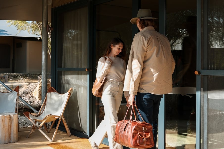 Two people walking into their Glamping tent