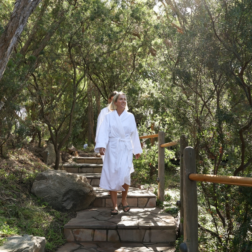 Two people walking down the path in white robes