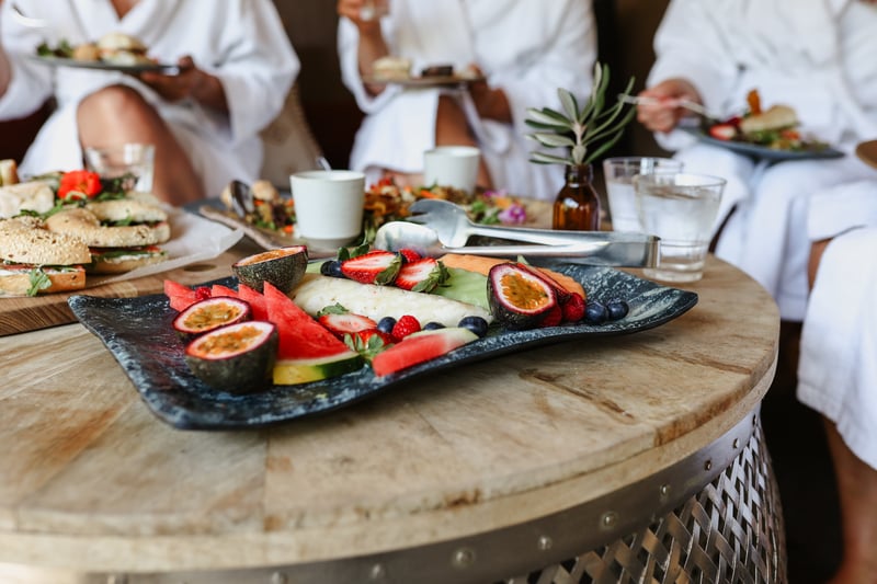 A platter of fruit with a group of people in white robes in the background