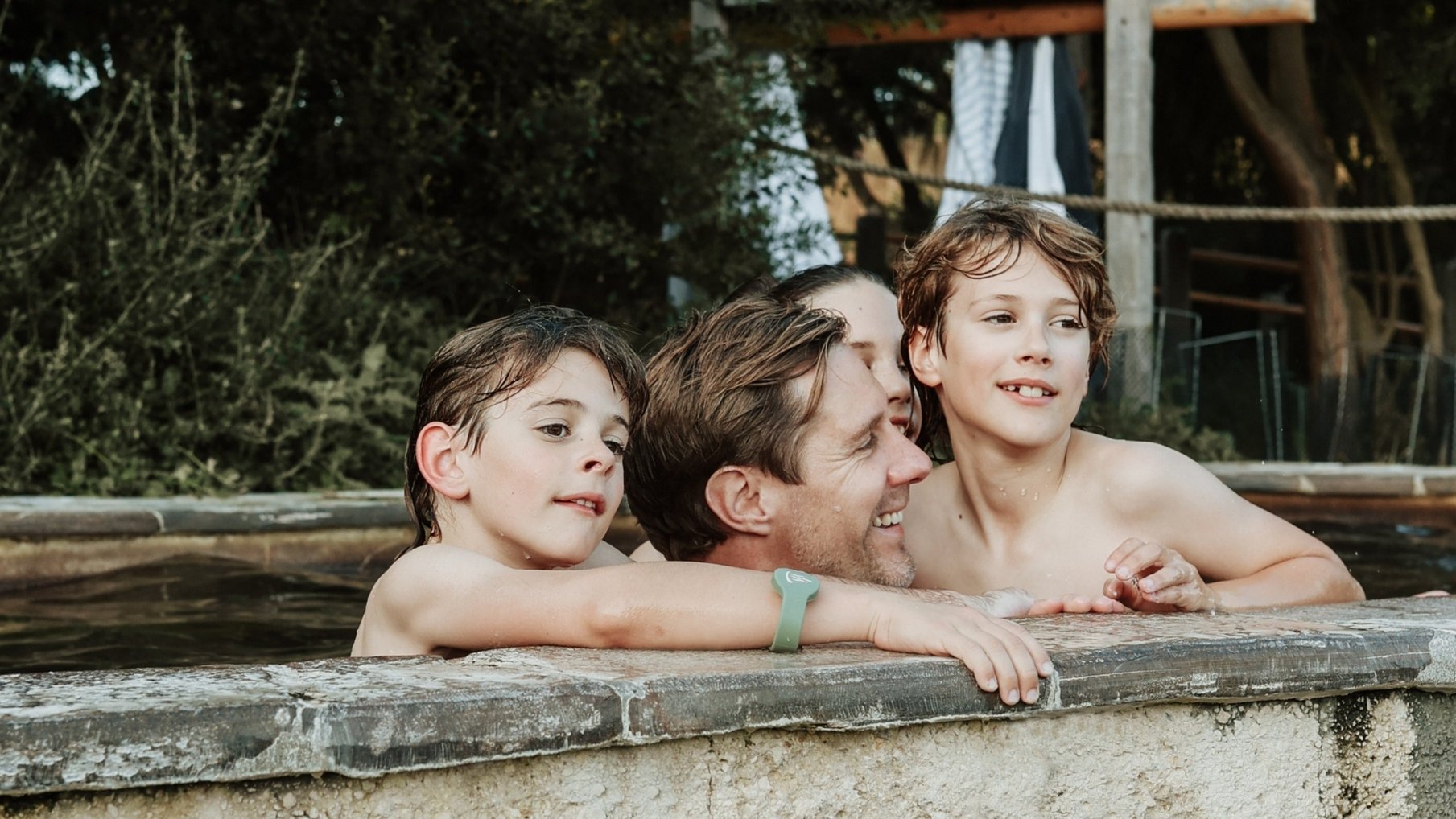 A father and his children bathing in hot springs