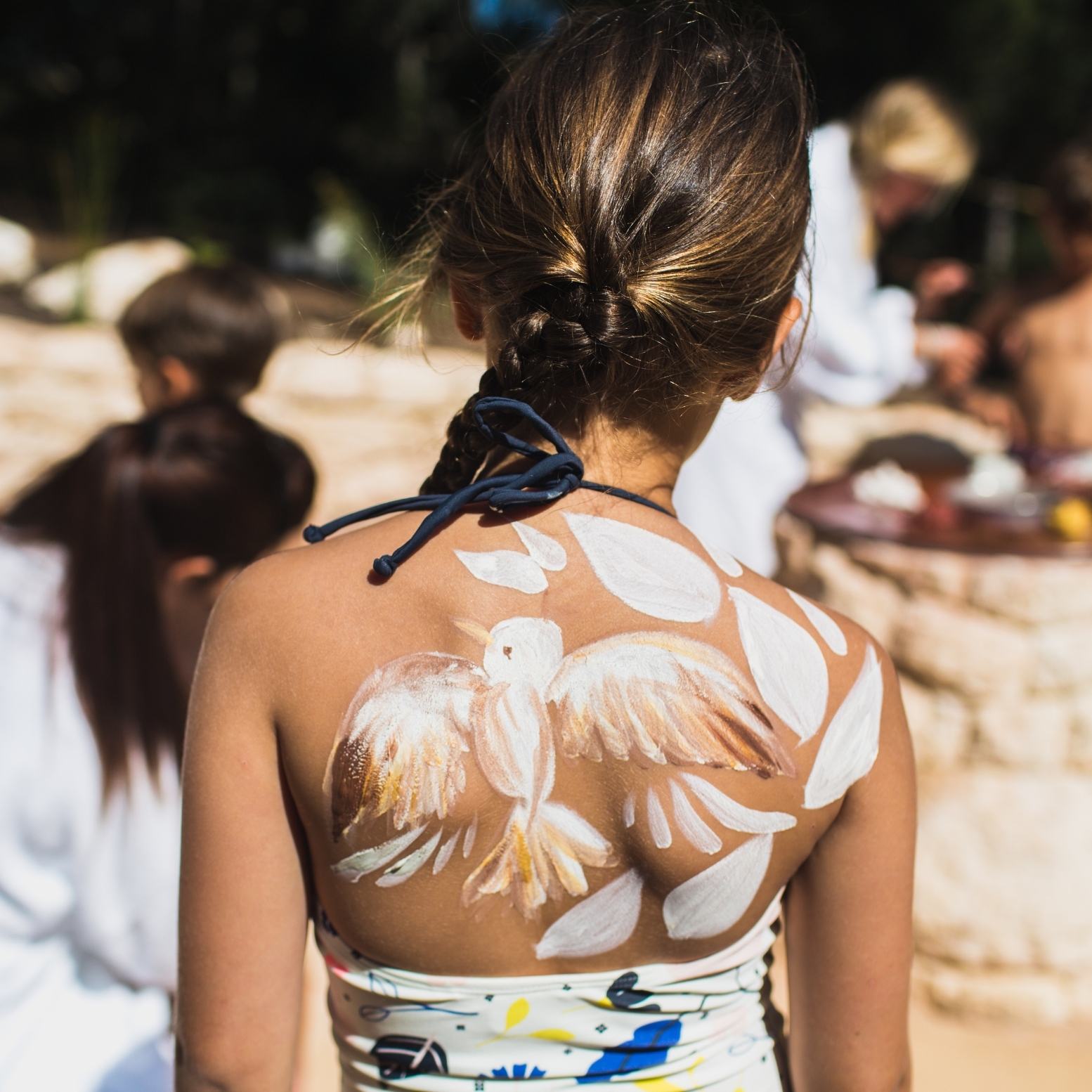 A young child with clay on her back