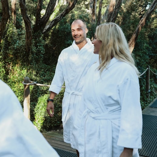 Two people walking through the Spa Dreaming Centre in white robes