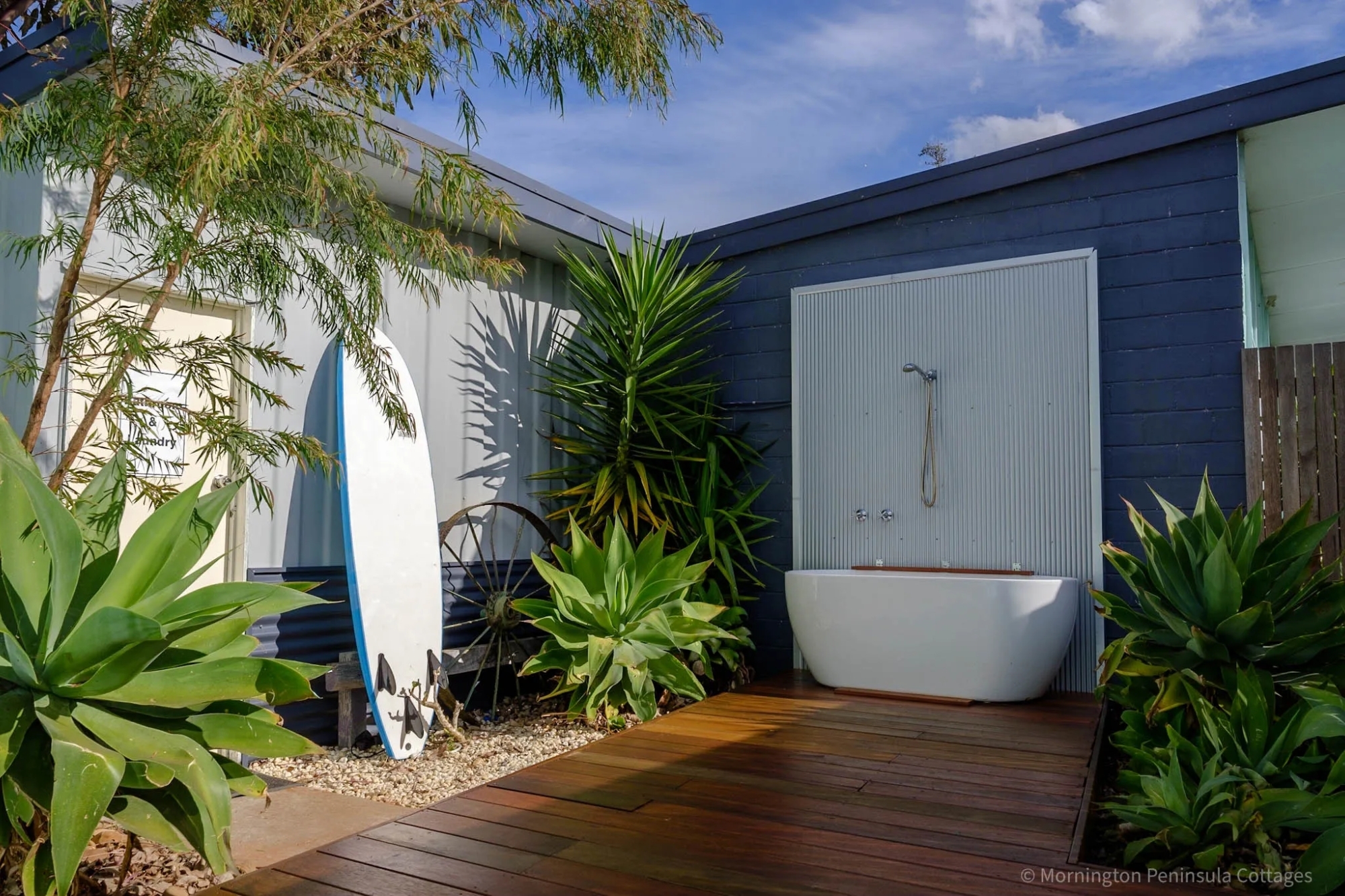 An outside bath against a blue exterior wall