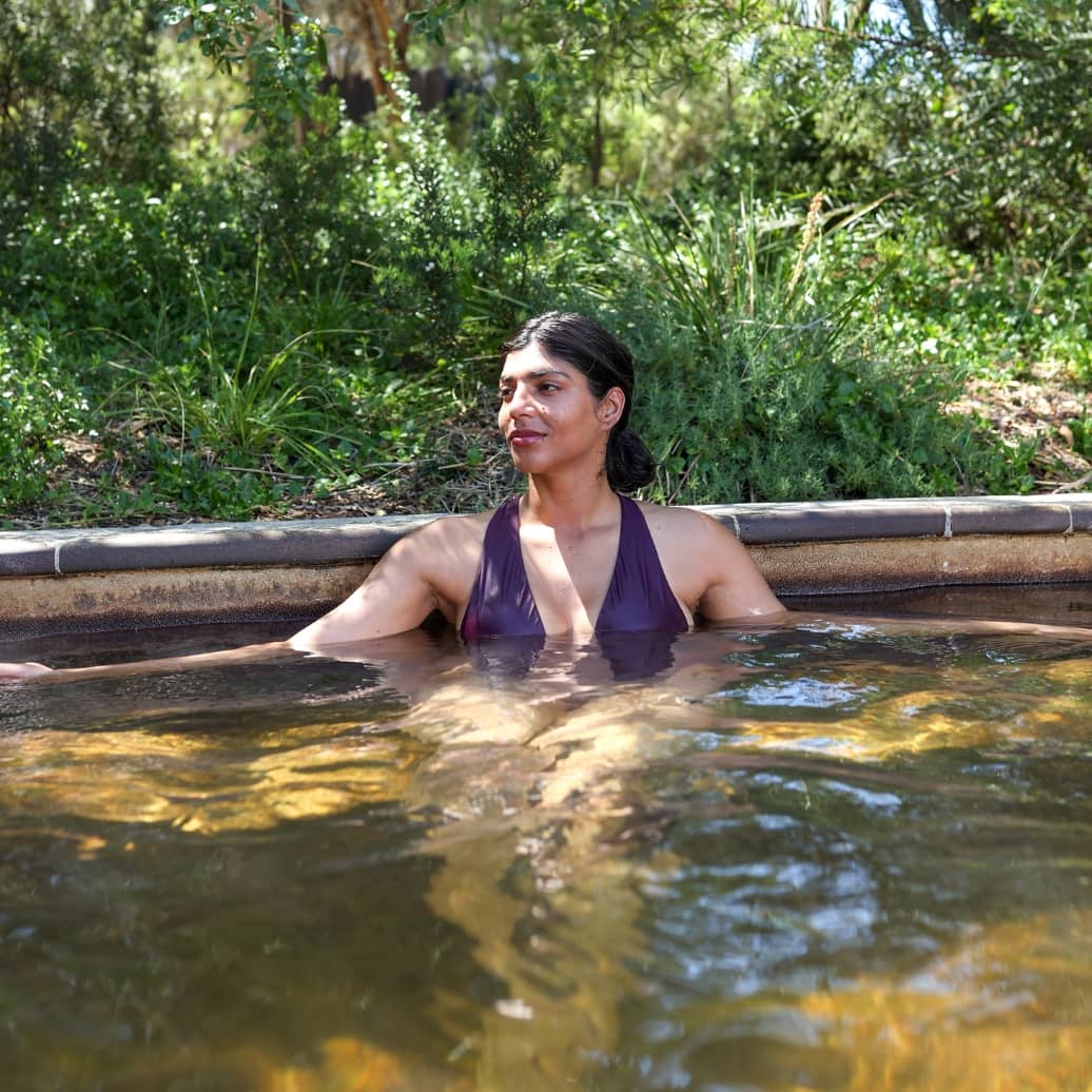 A woman relaxing in a hot spring pool in the Bath House