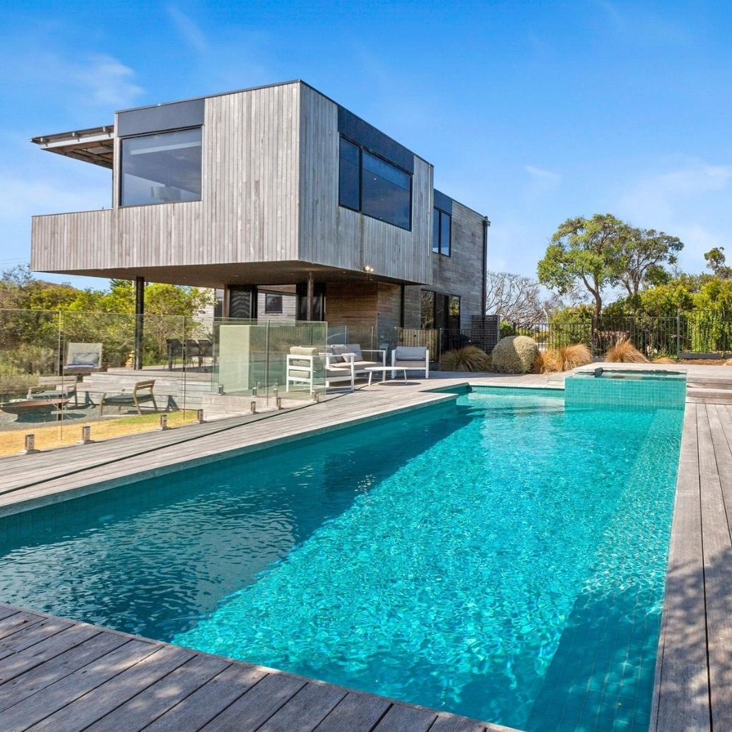 The view of a double story house with a pool