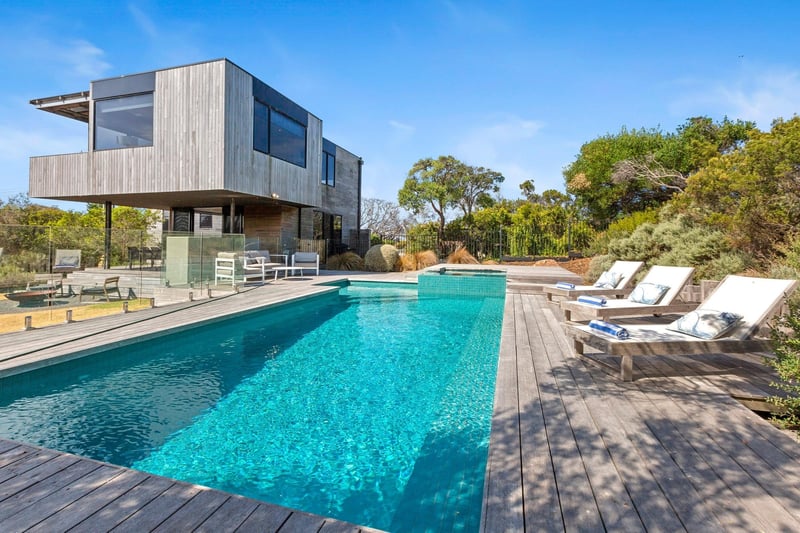 The view of a double story house with a pool