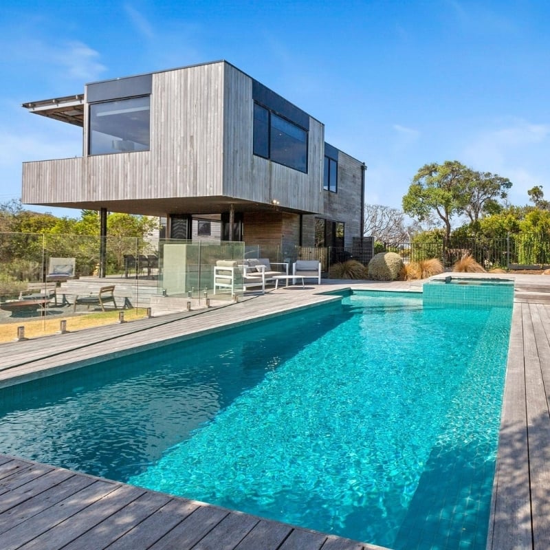 The view of a double story house with a pool