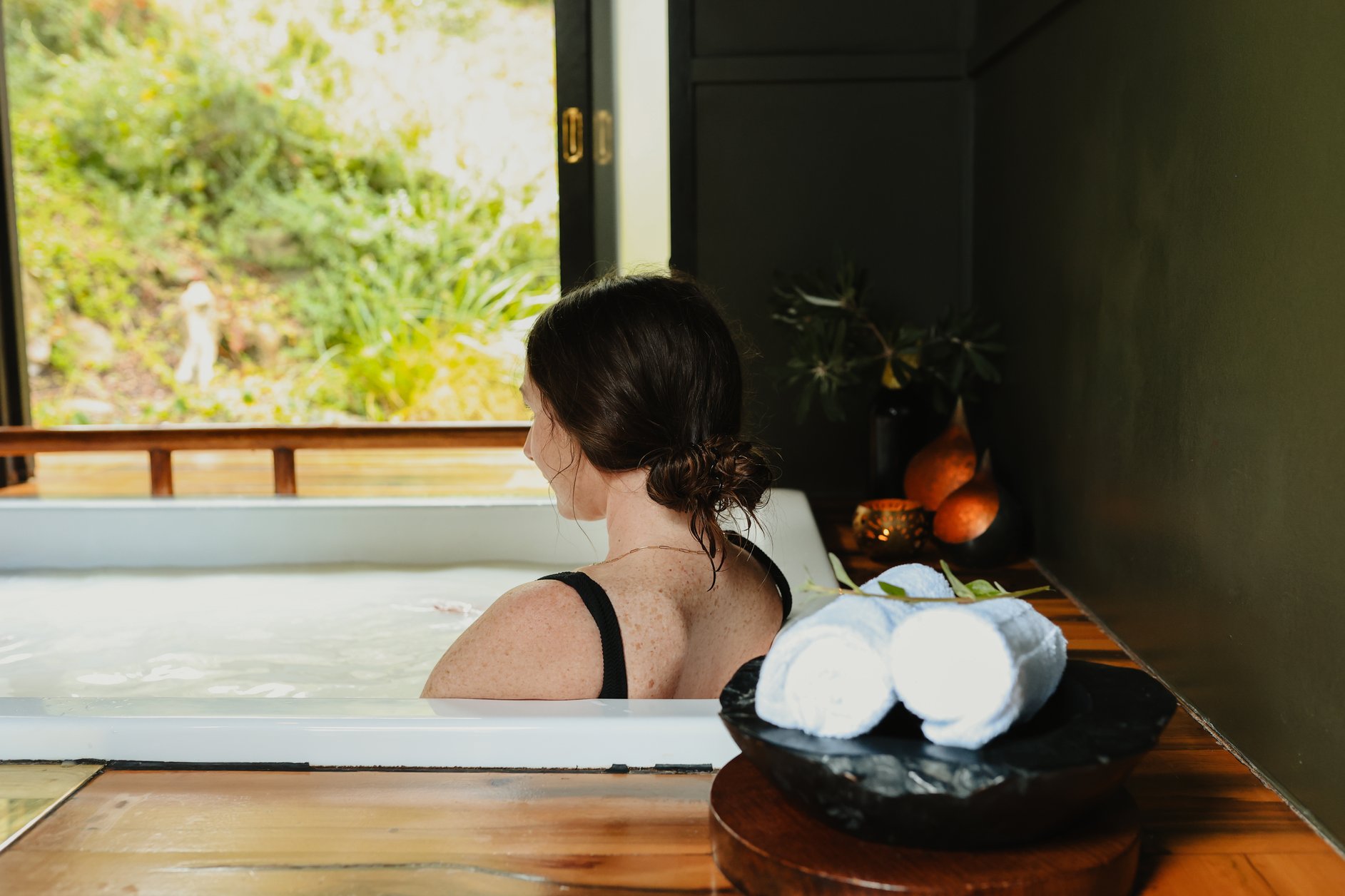 A woman looking out the window of a private bathing pavilion