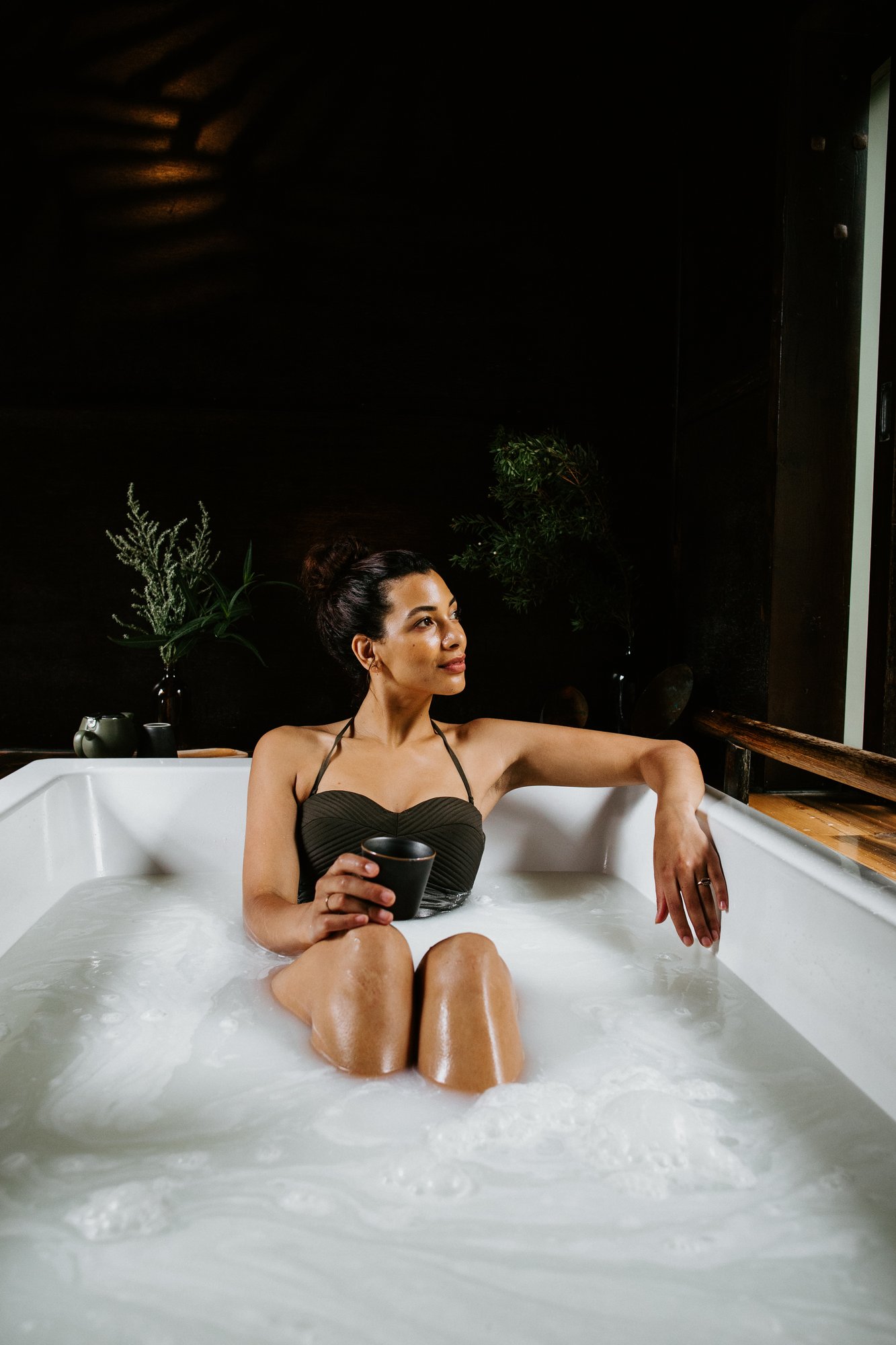 A woman bathing in an indoor private bath