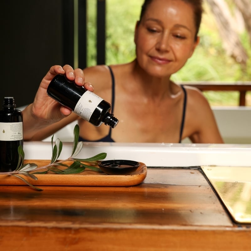 A woman adding essential oils to her private bath