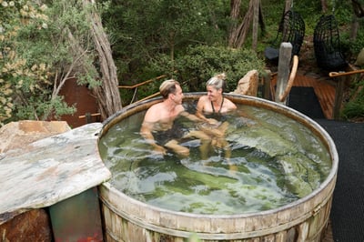 A man and woman bathing in the barrel pool